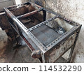 The iron table that houses the trader's stove looks dirty, the table has been used for annual trading 114532290