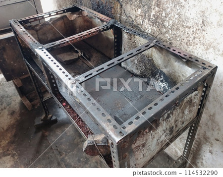 The iron table that houses the trader's stove looks dirty, the table has been used for annual trading 114532290
