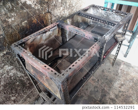 The iron table that houses the trader's stove looks dirty, the table has been used for annual trading 114532291
