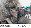 The iron table that houses the trader's stove looks dirty, the table has been used for annual trading 114532292