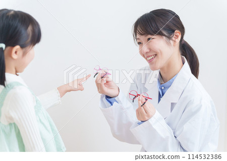 Eye doctor and amblyopic child choosing glasses 114532386
