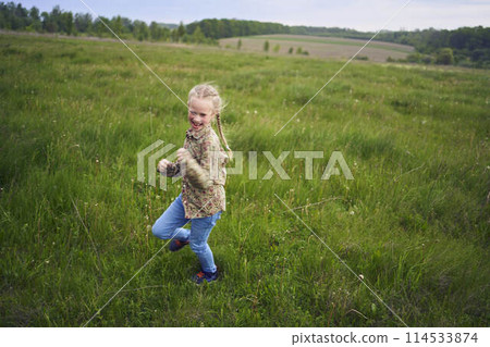 girls play catch up in a field 114533874