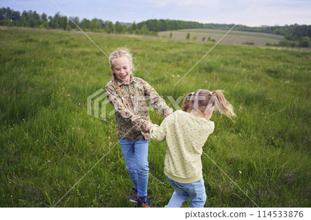 sisters hug and protect each other from the wind in the field sisters hug and protect each other from the wind in the field 114533876