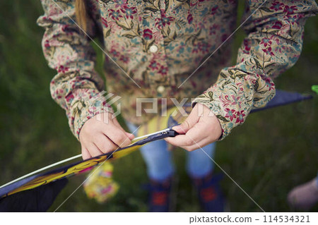 two little sisters repair and fly a kite in a field two little sisters repair and fly a kite in a field 114534321