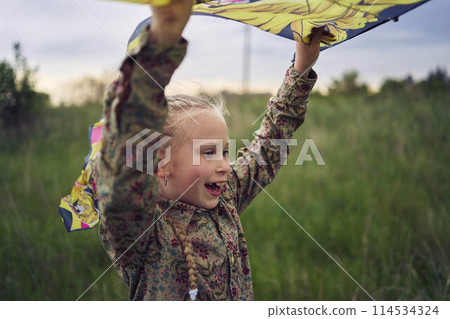 two little sisters repair and fly a kite in a field two little sisters repair and fly a kite in a field 114534324