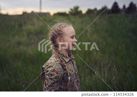 a portrait of a little blond girl in a field 114534326