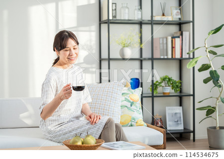 A middle woman relaxing in the living room. A middle woman relaxing in the living room. 114534675