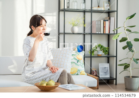 A middle woman relaxing in the living room. 114534679