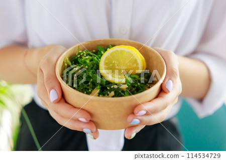 Hiyashi Wakame Salad In Kraft Food Delivery Container In Female Hands, Chuka Salad 114534729