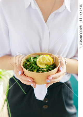 Hiyashi Wakame Salad In Kraft Food Delivery Container In Female Hands, Chuka Salad Hiyashi Wakame Salad In Kraft Food Delivery Container In Female Hands, Chuka Salad 114534730