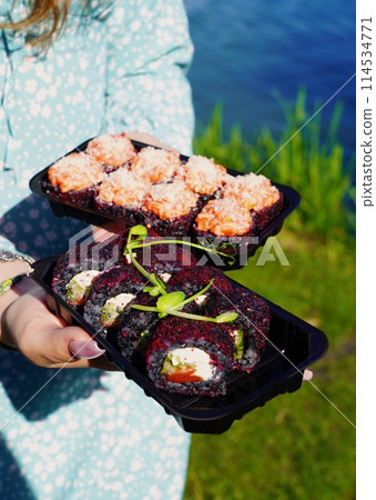 Sushi roll Philadelphia with salmon, smoked eel, avocado, cream cheese on black background. Sushi menu. Japanese food. Sushi roll Philadelphia with salmon, smoked eel, avocado, cream cheese on black background. Sushi menu. Japanese food. 114534771