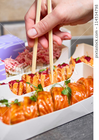 Sushi roll Philadelphia with salmon, smoked eel, avocado, cream cheese on black background. Sushi menu. Japanese food. Sushi roll Philadelphia with salmon, smoked eel, avocado, cream cheese on black background. Sushi menu. Japanese food. 114534798