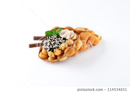 Hong kong or bubble waffle with ice cream, fruits, chocolate sauce and colorful candy isolated on white background Hong kong or bubble waffle with ice cream, fruits, chocolate sauce and colorful candy isolated on white background 114534831