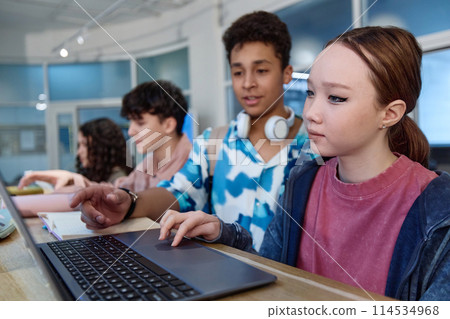Portrait of Asian teenage girl using laptop computer during tech class in modern school copy space Portrait of Asian teenage girl using laptop computer during tech class in modern school copy space 114534968