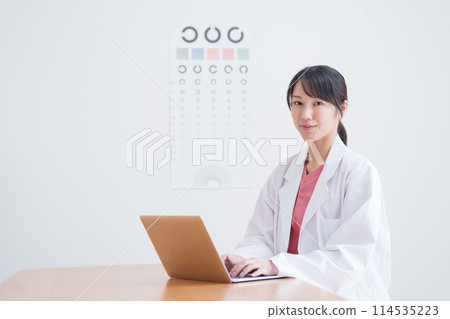 Ophthalmologist inputting data into a computer Ophthalmologist inputting data into a computer 114535223