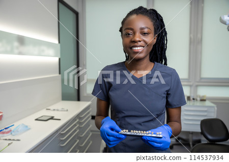 Smiling young female dentist in the office ready for dental prosthetics Smiling young female dentist in the office ready for dental prosthetics 114537934