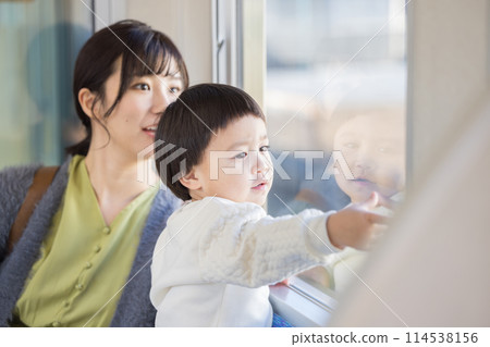 A child looking out of a train window. Photo courtesy of Keio Corporation. 114538156