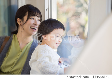 A child looking out of a train window. Photo courtesy of Keio Corporation. 114538159