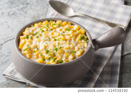 Creamy corn with cream, milk and grated parmesan closeup on the bowl. Horizontal 114538192