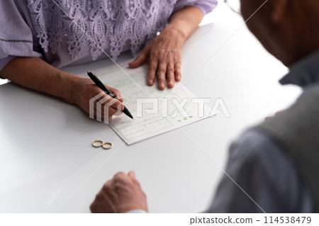 Senior couple divorce papers signing Senior couple divorce papers signing 114538479