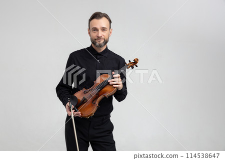 Adult man in black shirt playing violin Adult man in black shirt playing violin 114538647