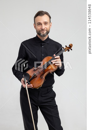 Adult man in black shirt playing violin 114538648