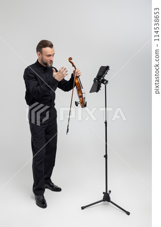 Full length of musician playing violin performing concert Full length of musician playing violin performing concert 114538653