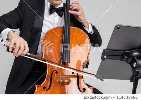 Unrecognizable male musician performing with cello and music note 114538666