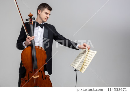 Young male musician performing with cello and music note 114538671