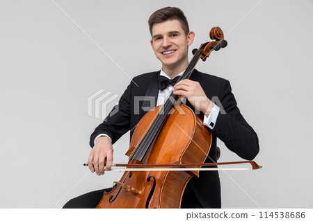 Musician sitting on chair playing cello 114538686
