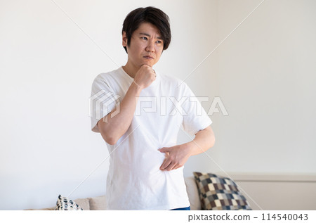 A man pinching his subcutaneous fat and thinking deeply A man pinching his subcutaneous fat and thinking deeply 114540043