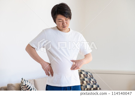 A man pinching his subcutaneous fat and feeling depressed A man pinching his subcutaneous fat and feeling depressed 114540047