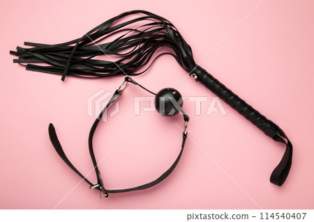 Set of erotic toys for BDSM on pink background. The game of sexual slavery with a whip and gag. Intimate sex games 114540407