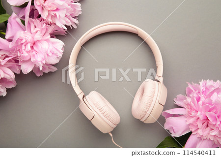 Modern pink headphones with flowers peonies on grey background 114540411