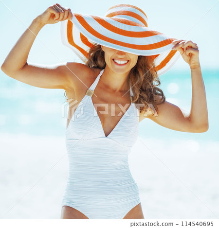 smiling young woman in hat on beach 114540695