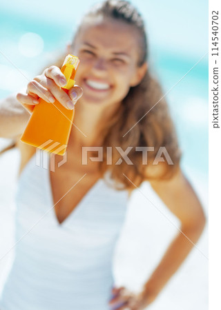 Closeup on young woman showing sun block creme 114540702