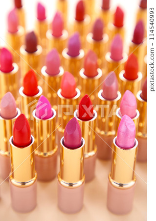 Many colorful lipstick on beige background, close up Many colorful lipstick on beige background, close up 114540993