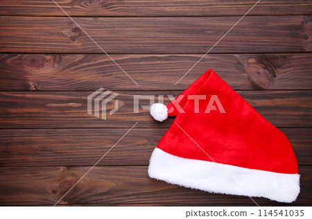 Santa Claus red hat on brown wooden background 114541035