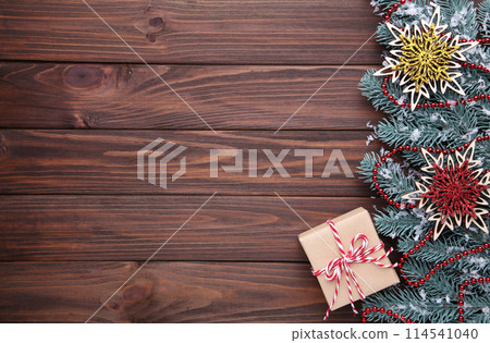 Snowflakes and gift on a brown wooden background. 114541040