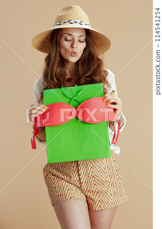 happy 40 years old woman in blouse and shorts on beige 114541254