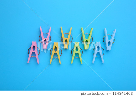 Plastic clothes pins on a blue background Plastic clothes pins on a blue background 114541468