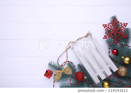 Christmas toy sledge with fir-tree branch on a white background. Christmas toy sledge with fir-tree branch on a white background. 114541612