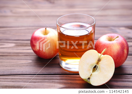 Red apples with juice on a brown background 114542145