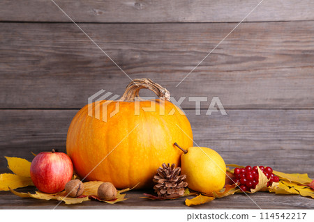 Orange pumpkin with leaves and vegetables on grey 114542217