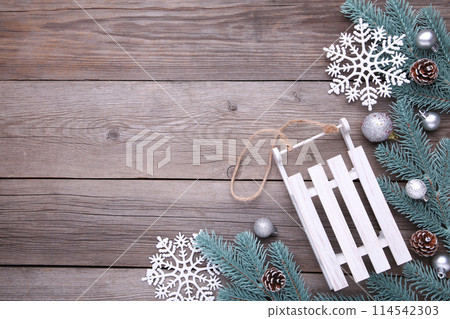 Christmas toy sledge with fir-tree branch on a grey background 114542303