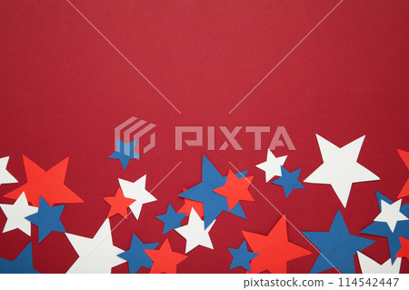 American independence day, celebration, patriotism and holidays concept - red, white and blue paper stars on red background. American independence day, celebration, patriotism and holidays concept - red, white and blue paper stars on red background. 114542447