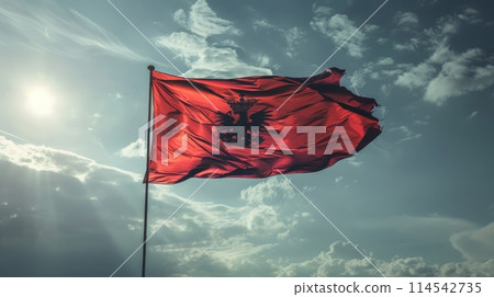 vibrant red flag billows gracefully in the wind, conveying a message of strength, power, and resilience. 114542735