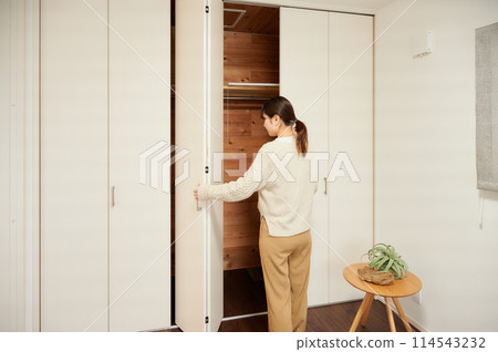 Woman opening a closet 114543232