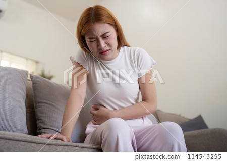 Asian woman having painful from stomach ache at home, Female suffering with abdominal pain Asian woman having painful from stomach ache at home, Female suffering with abdominal pain 114543295