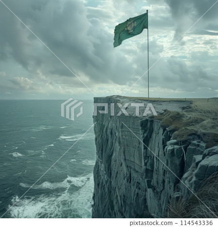 green flag flutters proudly in the breeze above the vast expanse of the ocean, set against a dramatic cliff backdrop. 114543336